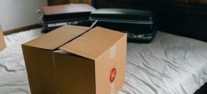 a box and suitcases on a bed