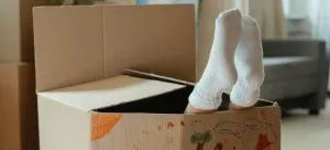 Kid playing with moving box, one of ways to lift your family's mood on moving day