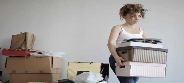 A woman carrying a stack of boxes