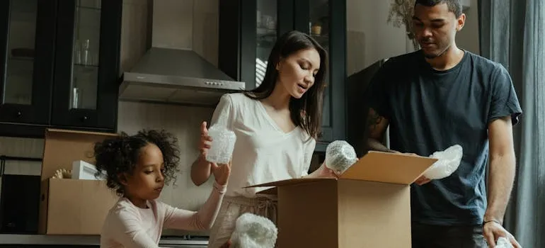 A family packing a box while discussing which items you shouldn't bother storing