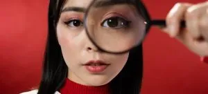 A woman looking through a magnifying glass.