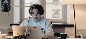 A man using a laptop and doing research about whether you should start your business in Hong Kong or not.