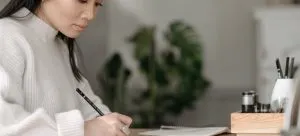 A woman writing in a notebook.
