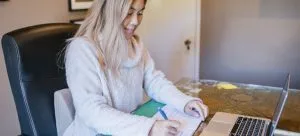 Woman signing papers.