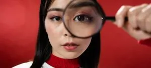A woman holding a magnifying glass.