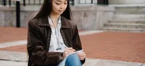 A student sitting in front of a university. Education is another reason why people are moving from Europe to Hong Kong.