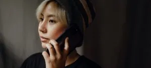 A woman talking on a mobile phone. Use a phone to call and book movers when moving from Jiangmen to Hong Kong.