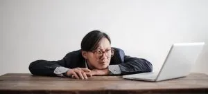A man using a laptop and doing research for the Visa application when moving from Hong Kong to Manchester.