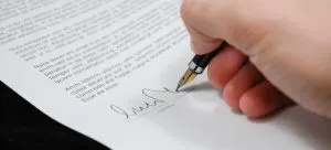 A person signing a contract.