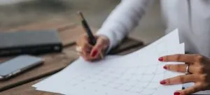 A woman filing a calendar and creating a timeline, which is important when you want to make international moving easier.