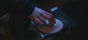 A person putting a cd in a computer.
