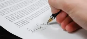 A person signing a contract.